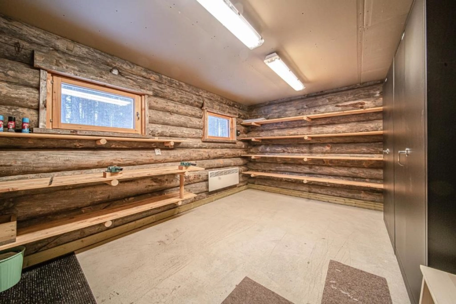 Lämmin suksienhuoltotila autokatoksen yhteydessä